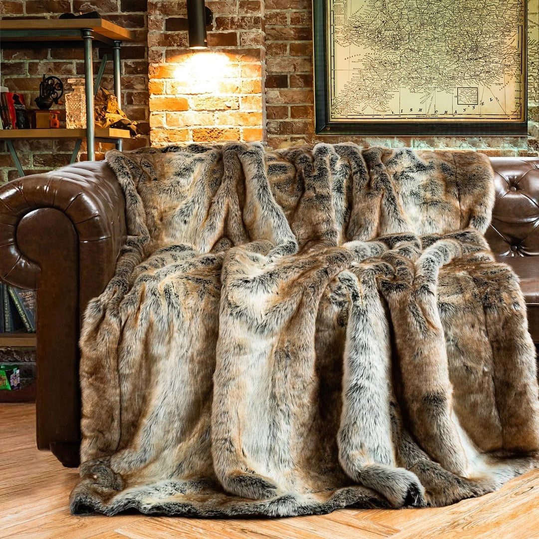 Plaid doux en fausse fourrure beige sur canapé gris, apportant chaleur et confort au salon cosy.
