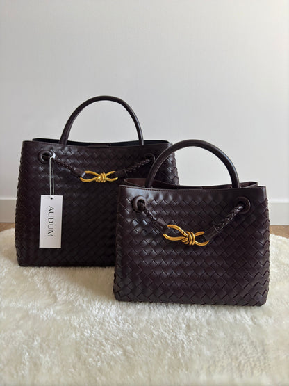 Femme portant petit sac à main tressé, style chic et sophistiqué.