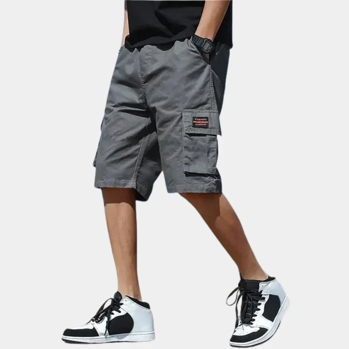Short cargo homme robuste avec poches utilitaires, parfait pour activités extérieures et mode estivale.