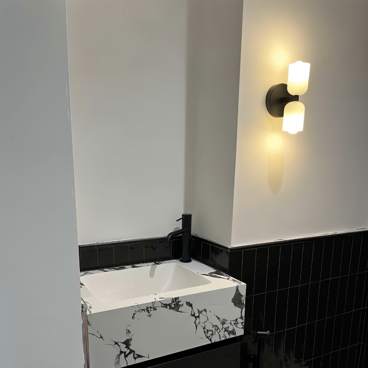 Lampe murale élégante, double éclairage haut/bas, accentue la décoration moderne de la pièce.