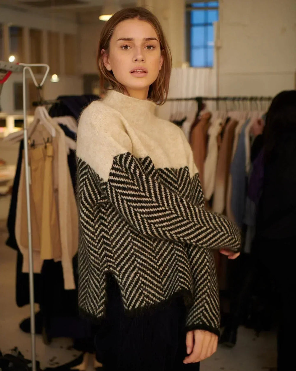 Pull femme bleu marine col montant, très confortable et chaud, orné d'un motif chevron. Parfait pour l'hiver.