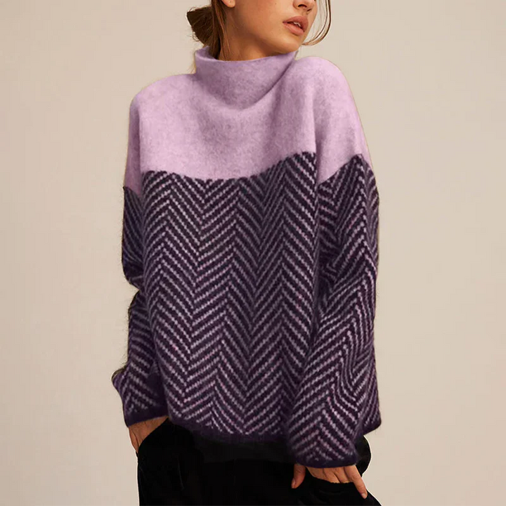 Pull femme chaud et chic à col montant. Son motif chevron distinctif et son confort en font un must-have mode hiver.