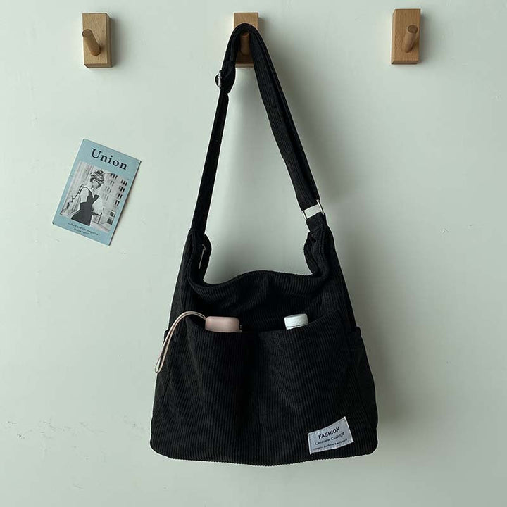 Sac à main femme décontracté en velours côtelé noir, style urbain moderne, parfait pour le travail.