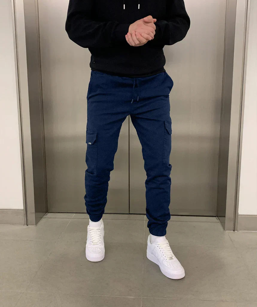 Silhouette d'un homme portant un pantalon jogger cargo ajusté, combinant sport et élégance décontractée.