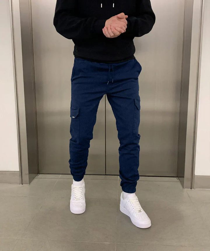 Silhouette d'un homme portant un pantalon jogger cargo ajusté, combinant sport et élégance décontractée.
