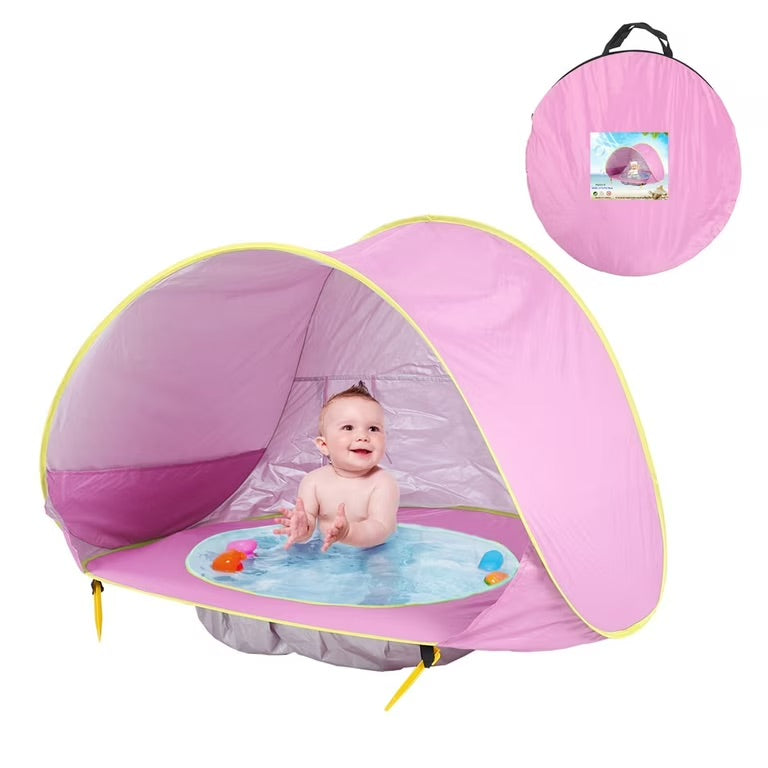 Enfant jouant joyeusement à l'ombre d'une tente de plage enfant anti-UV, protection solaire pour bébé à la plage.