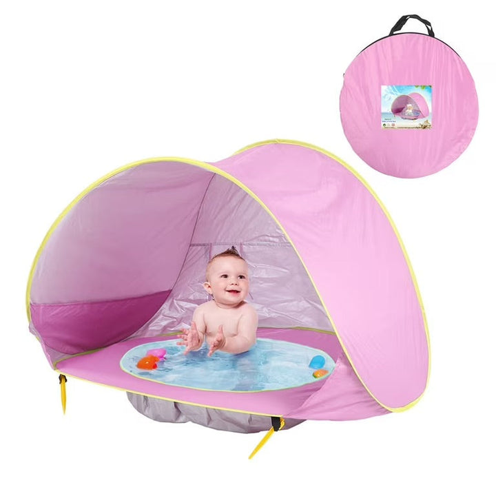 Enfant jouant joyeusement à l'ombre d'une tente de plage enfant anti-UV, protection solaire pour bébé à la plage.