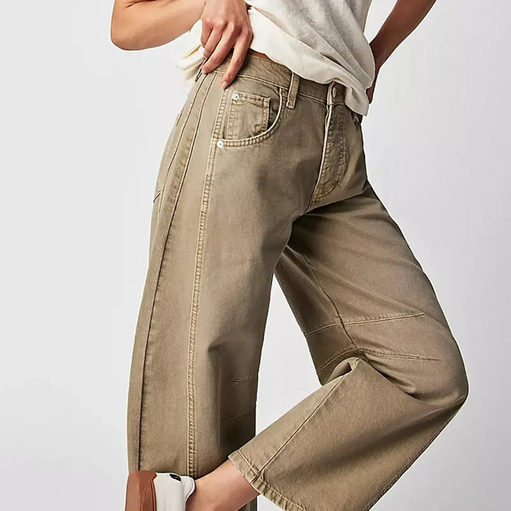 Femme portant un jean taille haute coupe baril, look moderne et confortable avec coutures apparentes.