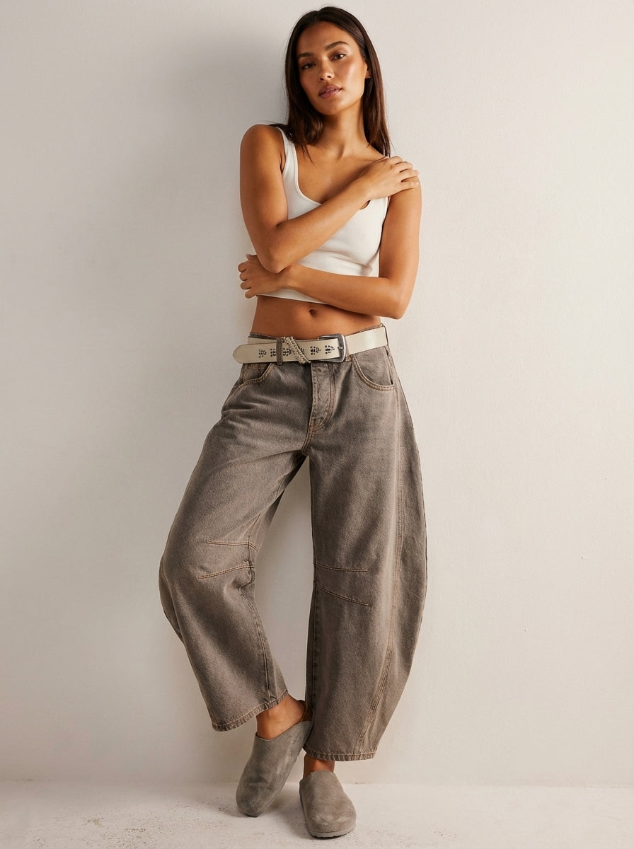 Zoom sur les détails couture d'un jean femme taille haute coupe baril. Tissu denim de qualité.