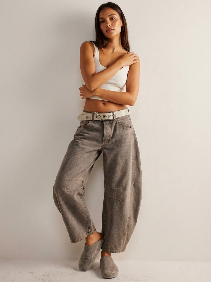 Zoom sur les détails couture d'un jean femme taille haute coupe baril. Tissu denim de qualité.