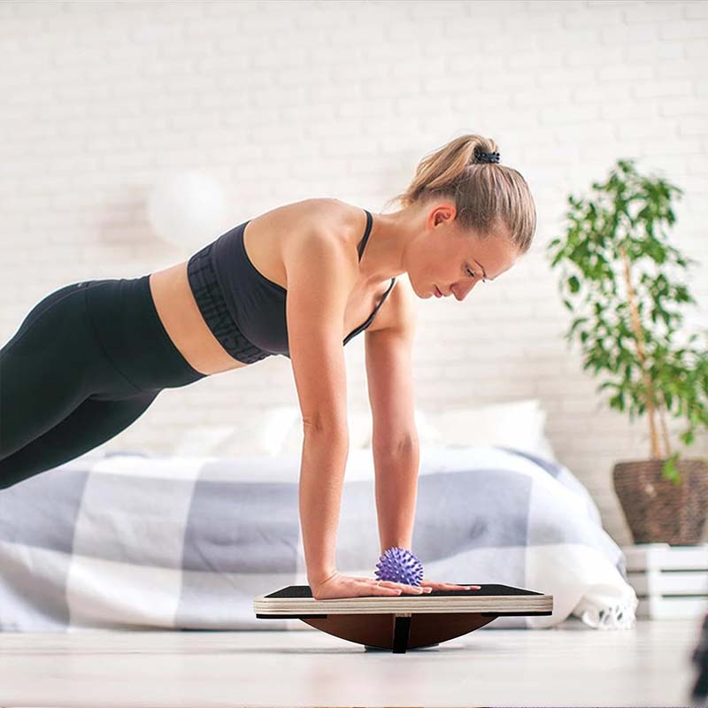 Planche d'équilibre en bois naturel pour exercices de fitness, renforçant force et équilibre corporel.