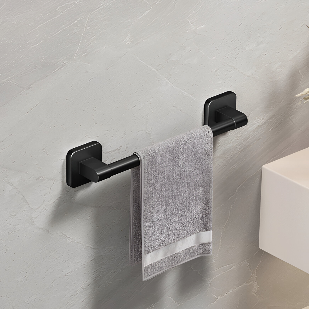 Détail du porte-serviettes noir autocollant fixé au mur de la salle de bain, support solide pour serviettes.
