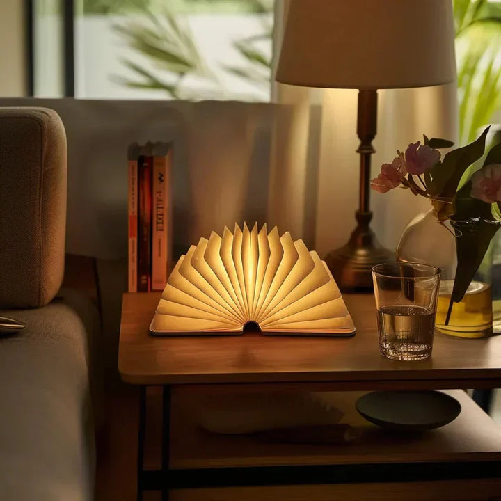 Lampe de livre design StoryGlow en bois clair, lumière LED chaude pour un intérieur moderne et chaleureux.