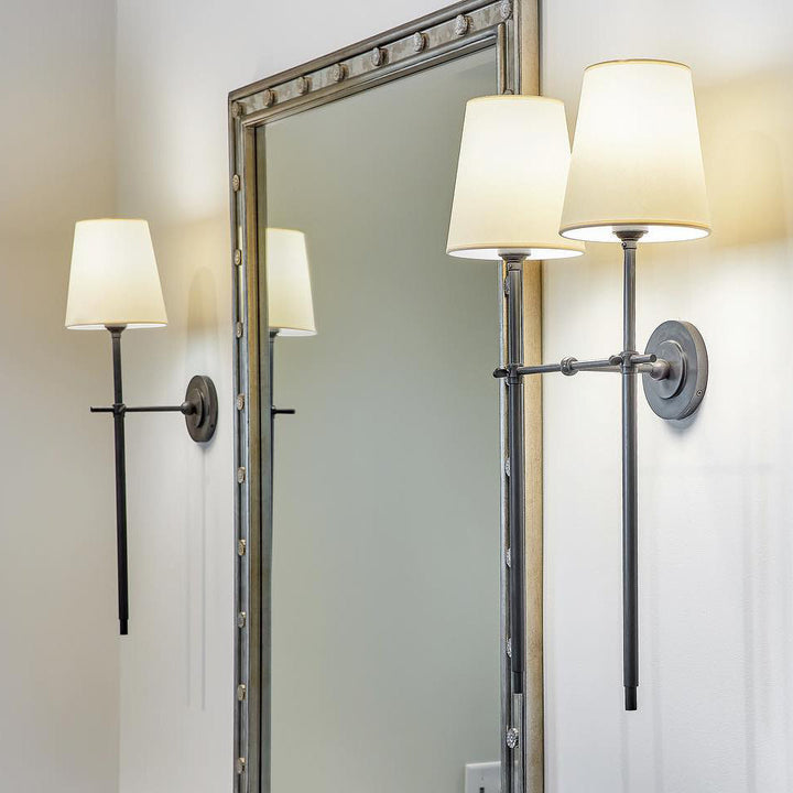 Applique murale élégante bras laiton, abat-jour tissu blanc. Éclairage intérieur doux pour salon moderne.