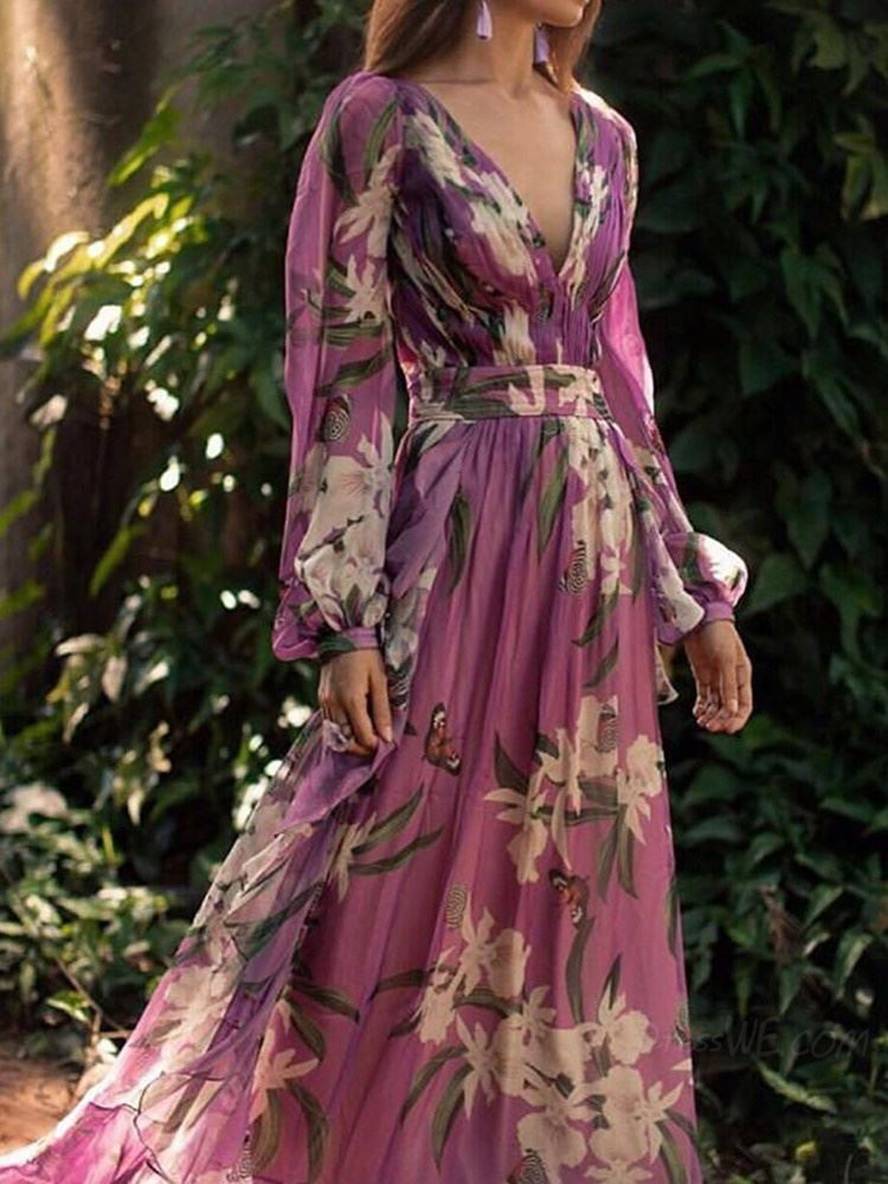 Femme portant robe maxi fluide violette à motif floral, col V. Parfaite pour une soirée élégante ou un événement estival.