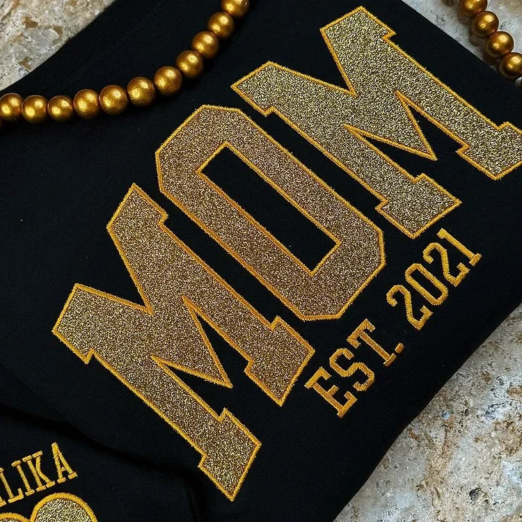 Gros plan sur un sweat-shirt maman personnalisé, affichant un message d'amour unique pour la fête des mères.