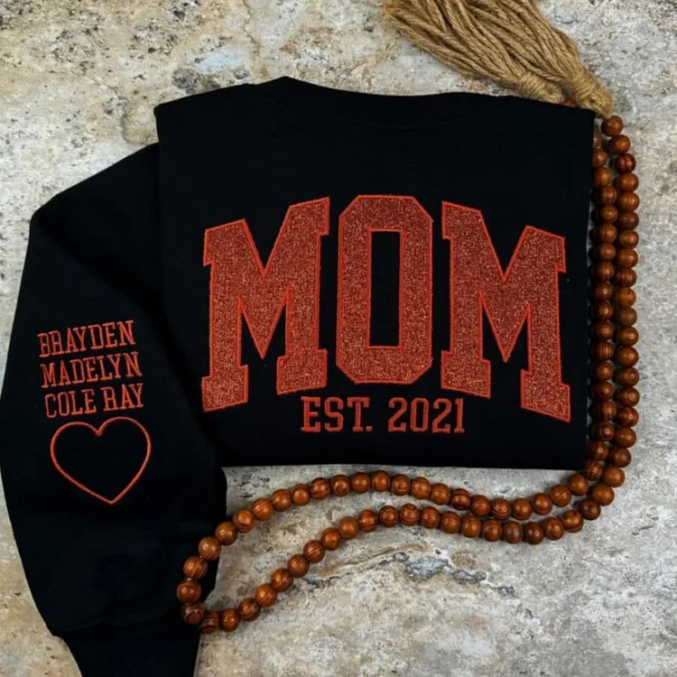 Maman souriante portant un pull personnalisé doux, symbole de son rôle unique dans la famille.