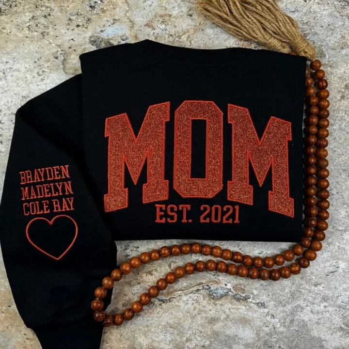 Maman souriante portant un pull personnalisé doux, symbole de son rôle unique dans la famille.