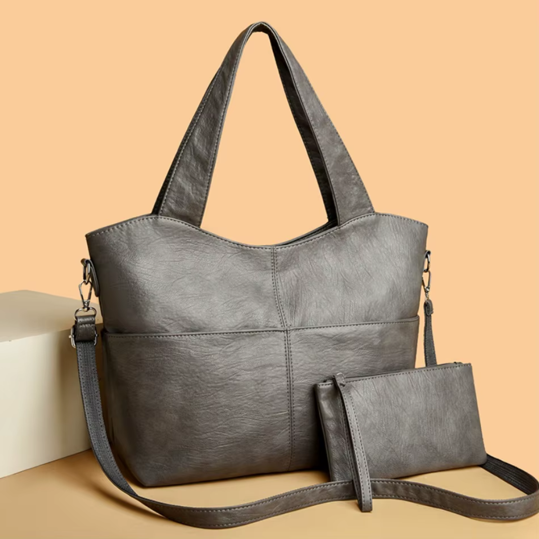 Sac femme gris structuré avec double anses et bandoulière, en similicuir. Élégant et pratique pour toutes occasions.