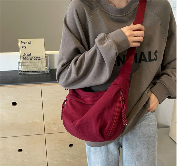 Grand sac banane pratique pour femme avec tissu déperlant et bandoulière réglable.