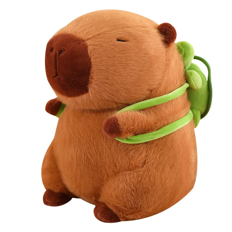 Peluche capybara douce et marron avec un petit sac à dos tortue verte, idéal comme jouet ou doudou pour enfant.