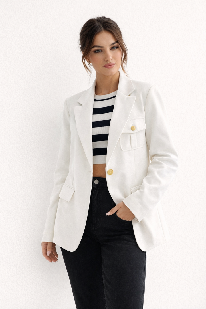 Femme portant un blazer ajusté élégant, look professionnel chic idéal pour le bureau ou une cérémonie.