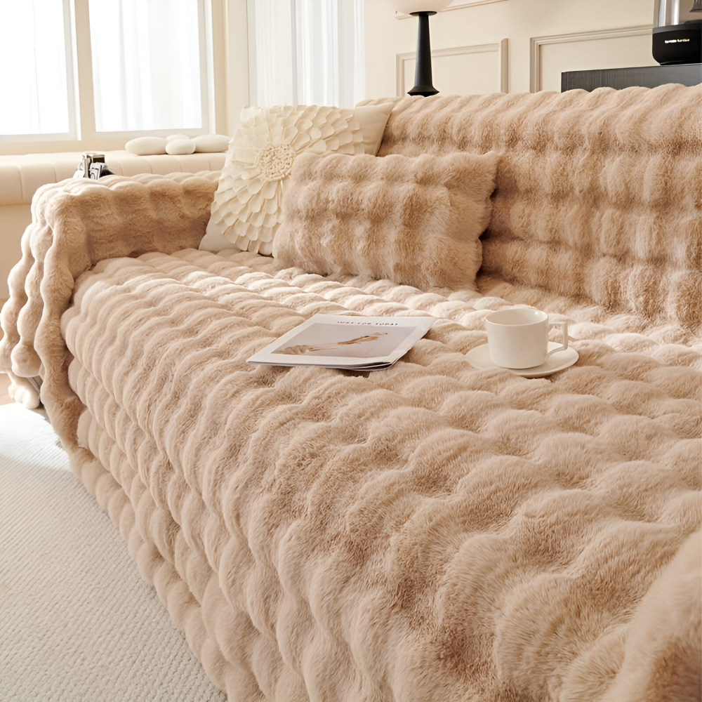 Couverture moelleuse en polaire pour le canapé, ajoutant une touche de douceur à la décoration.