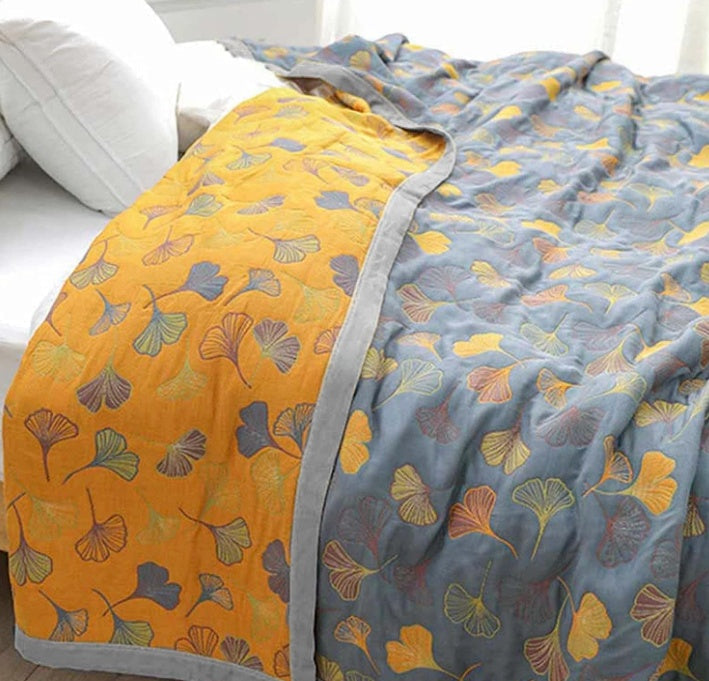 Motif détaillé des feuilles de Ginkgo sur la couette réversible jaune et bleue. Design naturel pour une literie élégante et cosy.