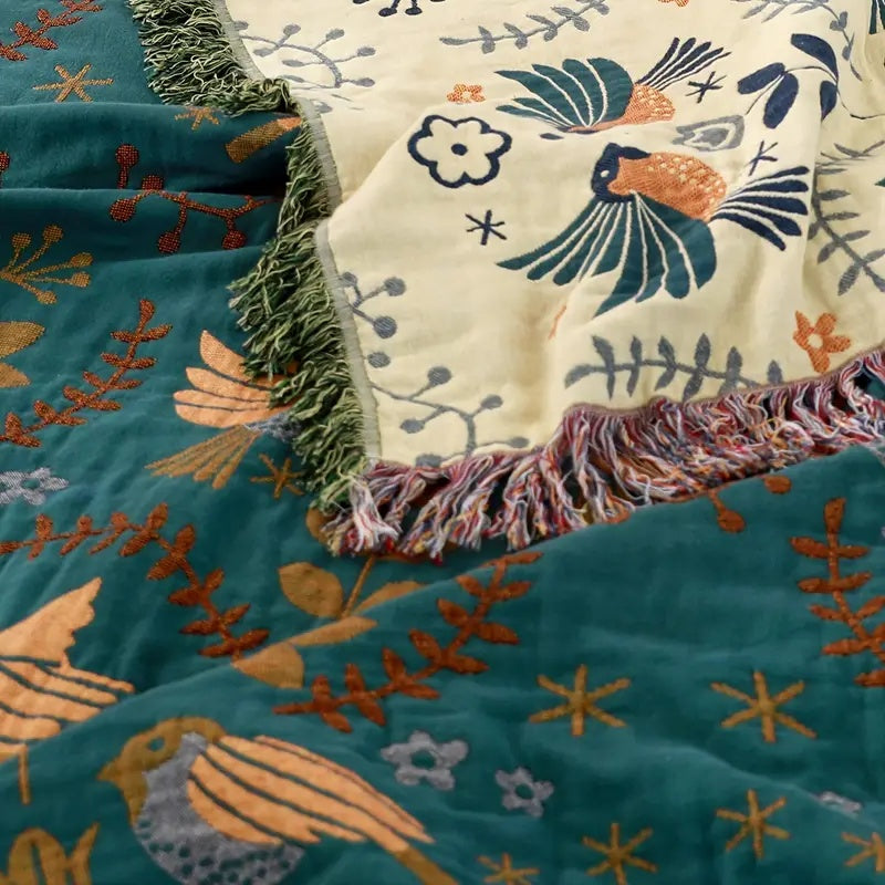 Décoration intérieure: élégante couverture en coton, motifs floraux et oiseaux, pour une chambre ou salon chaleureux.