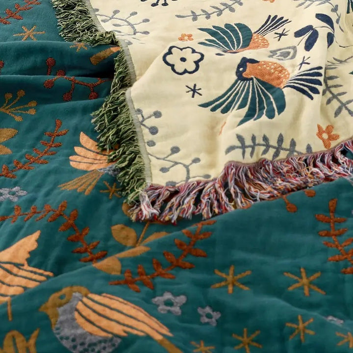 Décoration intérieure: élégante couverture en coton, motifs floraux et oiseaux, pour une chambre ou salon chaleureux.