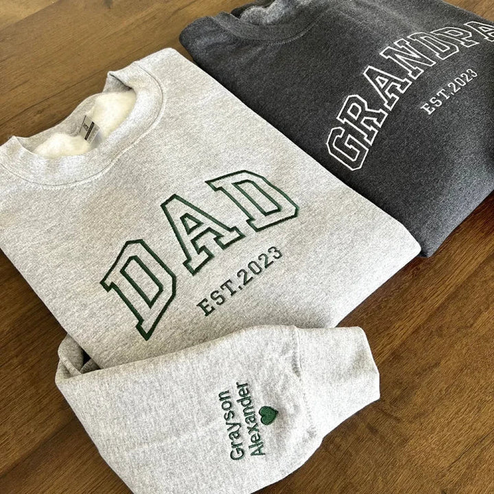 Pull homme brodé sur mesure, affichant des prénoms personnalisés. Vêtement unique pour le quotidien ou un cadeau spécial.