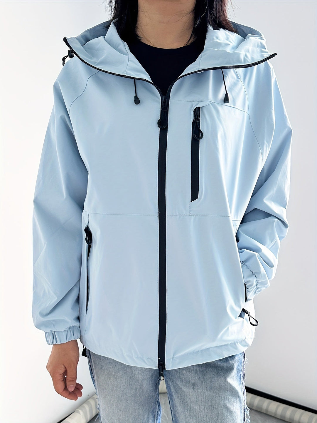 Veste légère imperméable femme à capuche, polyvalente pour la ville ou activités extérieures par temps frais.