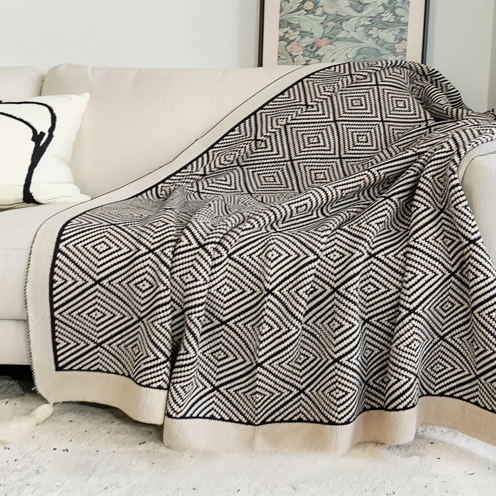Élégant plaid polaire géométrique noir et blanc, léger et confortable pour votre salon ou chambre.