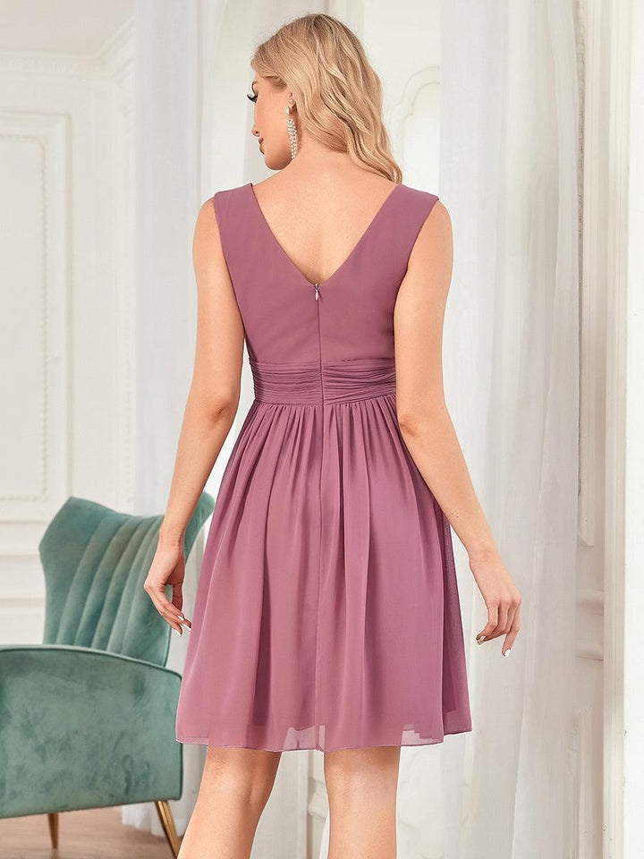 Demoiselle d'honneur en robe chic à col V, longueur midi, parfaite pour un mariage.