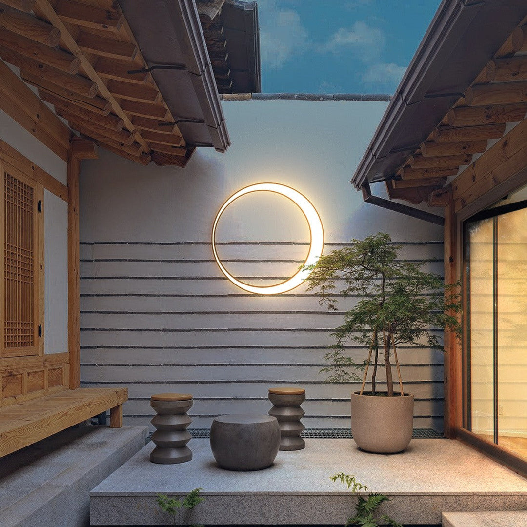 Luminaire mural extérieur LED circulaire moderne, design élégant pour jardin, terrasse ou façade.