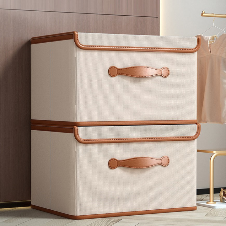 Boîte de rangement tissu pliable avec couvercle et poignées en cuir, idéale pour l'organisation maison.
