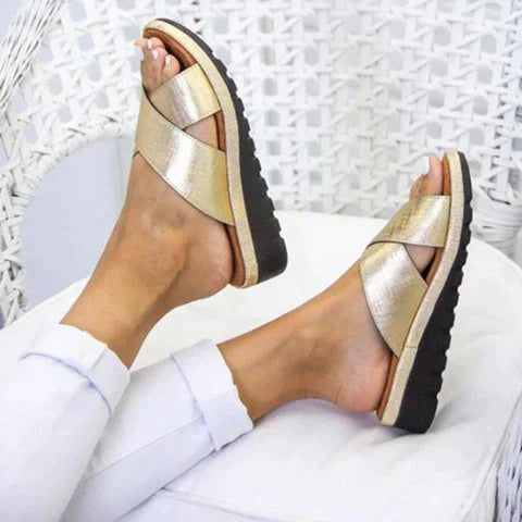 Femme enfilant les sandales Celia, confortables et élégantes, pour un look estival et une détente assurée.