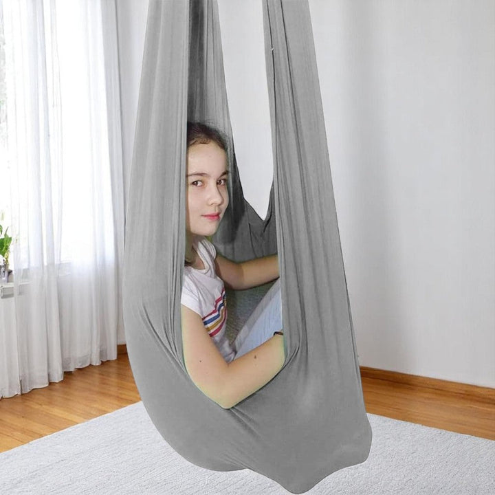 Enfant profitant d'une balançoire cocon sensorielle. Parfait pour autisme, TDAH, favorise le calme.