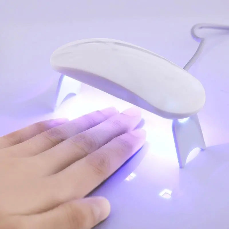 Mains appliquant des autocollants ongles gel UV. Manucure femme facile, rapide et sans bavure.