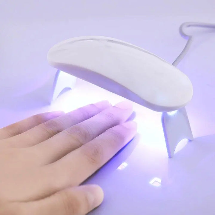 Mains appliquant des autocollants ongles gel UV. Manucure femme facile, rapide et sans bavure.