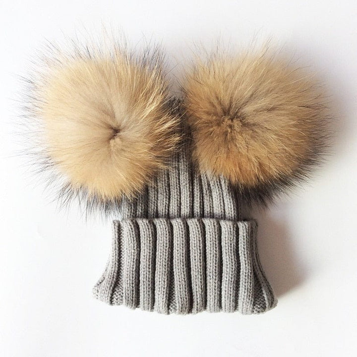 Bonnet fourrure doux et stylé avec deux pompons, parfait pour les sorties hivernales.