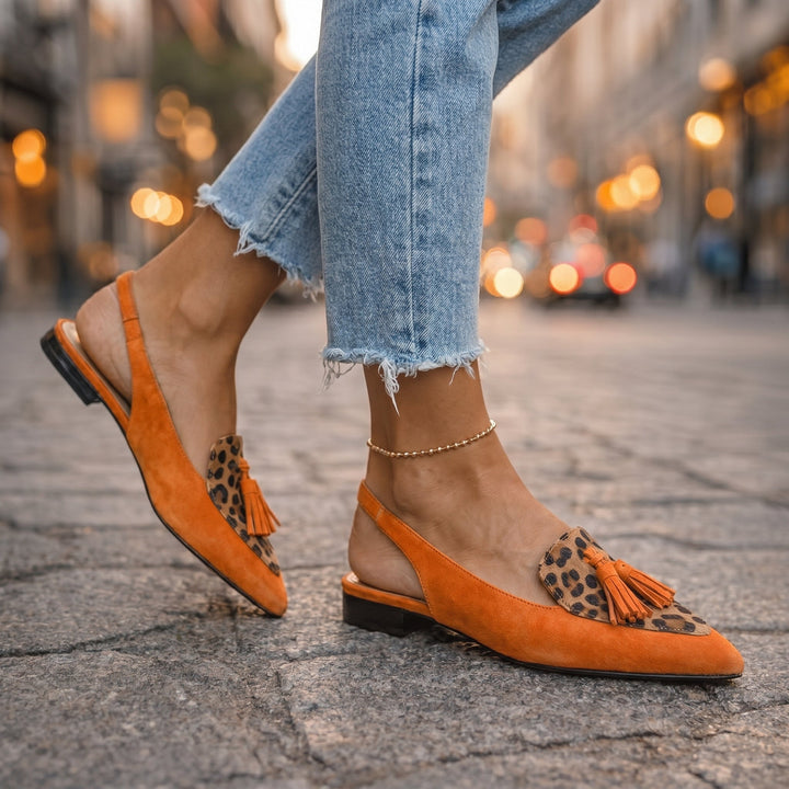 Mules femme élégantes et bicolores, ornées de pompons, parfaites pour une tenue estivale raffinée.