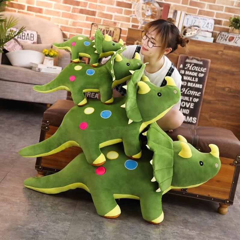 Enfant étreignant une peluche géante tricératops verte. Jouet dinosaure doux, compagnon idéal pour le jeu.