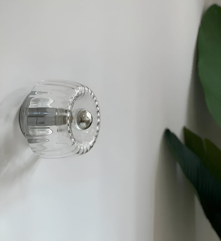 Luminaire LED mural élégant, verre strié, crée une ambiance chaleureuse dans la chambre.