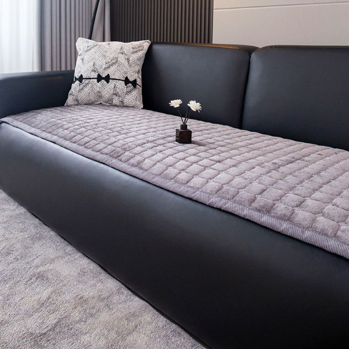 Housse de protection confortable pour canapé en peluche matelassée, pour un intérieur douillet et stylé.