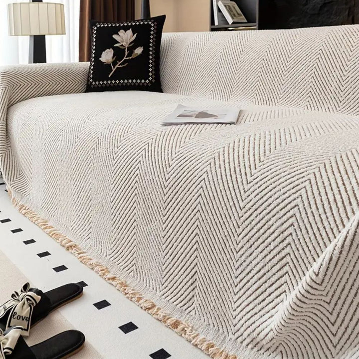 Housse de canapé ajustée avec motif chevrons et rayures. Ajoute style graphique et protection à votre salon.