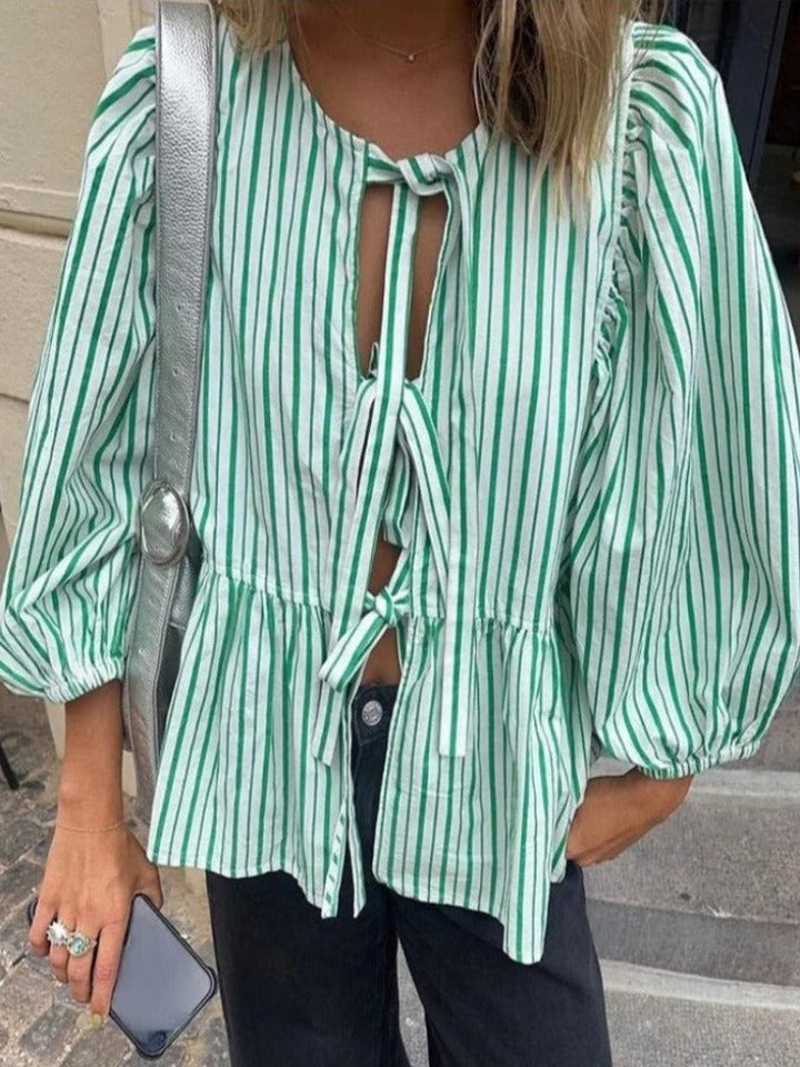 Haut rayé pour femme avec manches bouffantes. Design élégant et confortable, parfait pour le quotidien.