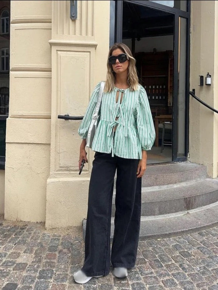 Haut femme chic à rayures et manches bouffantes. Blouse moderne et tendance, idéale pour un look décontracté.