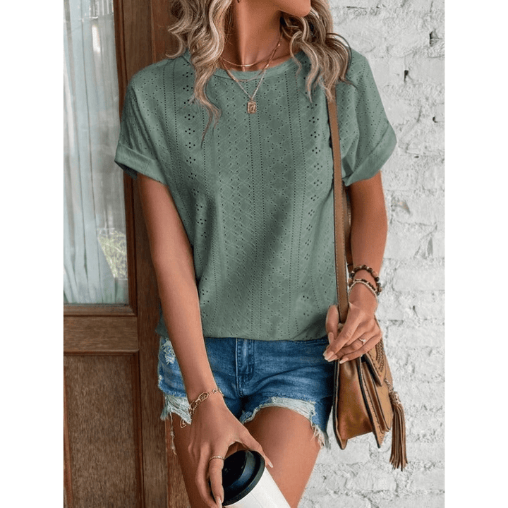 Blouse femme à broderie anglaise délicate, manches courtes. Chemisier élégant pour tenue estivale.