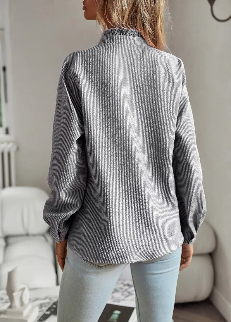 Chemisier femme ajusté, col montant, manches longues. Élégant et formel, idéal pour une tenue de bureau soignée.